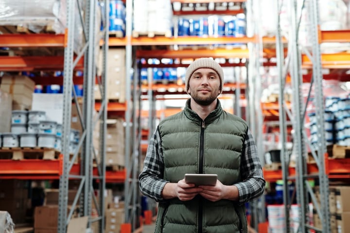 Man in Bubble Vest Holds an iPad in a Warehouse GDSN Salsify-1